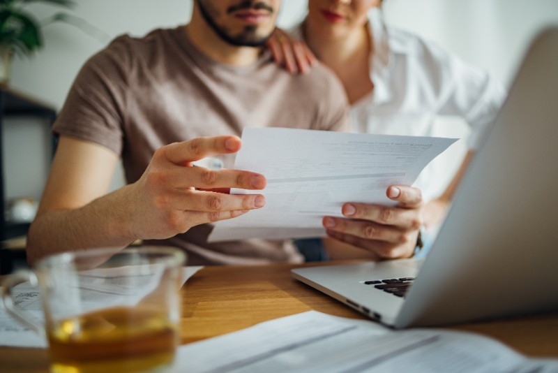 Unrecognizable Couple Paying Bills at Home