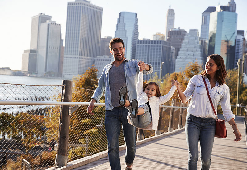 Young-family-with-daughter-taking-a-walk-on-footbridge